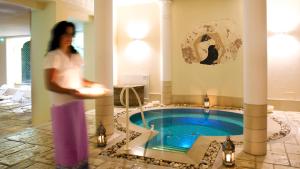una donna in piedi davanti a una piscina di Hotel Victoria & Iside Spa a Torino