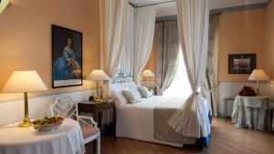 una camera da letto con un letto e un tavolo con una ciotola di frutta di Hotel Victoria & Iside Spa a Torino