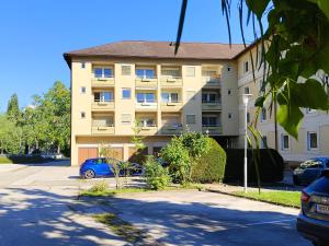 a building with a blue car parked in front of it at Grünerbalkon Ferienappartement in Klagenfurt