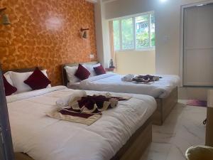 a hotel room with two beds with towels on them at Dulcify cottage sarangkot in Pokhara +28 photos