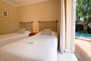 two beds in a room with a window at Villa Pippa in Puerto del Carmen +2 photos