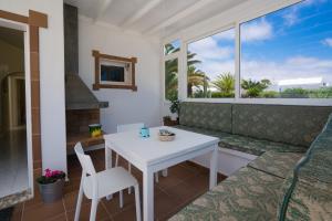 a white table and chair in a room with a window at Villa Pippa in Puerto del Carmen