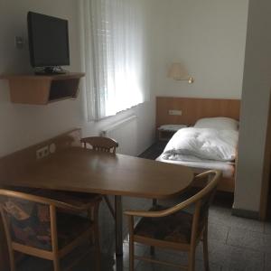 ein kleines Zimmer mit einem Tisch und einem Bett in der Unterkunft Gasthaus Keglerklause in Schwieberdingen