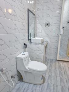 a white bathroom with a toilet and a sink at Zanzibar Luxury Bungalows in Tongoni