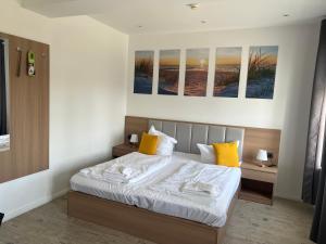 プットブスにあるBed & Breakfast am Schlossparkのベッドルーム1室(大型ベッド1台、黄色い枕付)