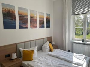 プットブスにあるBed & Breakfast am Schlossparkのベッドルーム1室(ベッド2台付)が備わります。壁には絵画が飾られています。