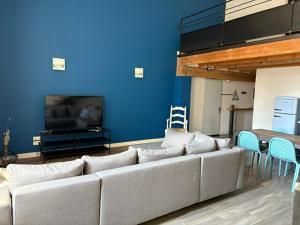 ein Wohnzimmer mit einem Sofa und einer blauen Wand in der Unterkunft Loft-style apartment, Pierrelatte in Pierrelatte + 6 Fotos