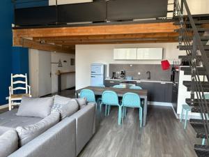 ein Wohnzimmer mit Couch und Tisch und eine Küche in der Unterkunft Loft-style apartment, Pierrelatte in Pierrelatte