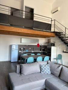 ein Wohnzimmer mit Couch und Küche in der Unterkunft Loft-style apartment, Pierrelatte in Pierrelatte