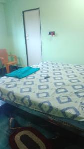a bed with a comforter on top of it at Arnav Lodge & Restaurant in Jhārsuguda