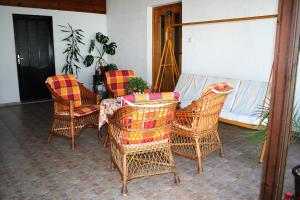 eine Terrasse mit Korbstühlen und einem Tisch in der Unterkunft Sobe Rooms Szobák Zimmer KIS in Palić