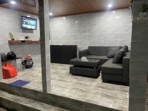 Una sala de estar con un sofá y un televisor. en Lestari Homestay Jimbaran, en Jimbaran