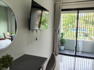 een spiegel in een kamer met een bed en een raam bij Le Wadee Residence in Bang Tao Beach