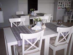 a table with white chairs and a table with flowers on it at Willa Oliwia in Ustka