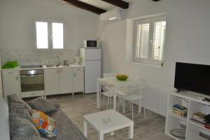 a kitchen and living room with a couch and a table at Apartments Martinis in Vis