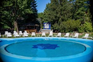 una gran piscina con sillas y una pantalla en Wellness Hotel Szindbád, en Balatonszemes
