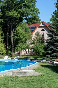 a swimming pool in the yard of a house at Wellness Hotel Szindbád in Balatonszemes