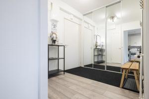 a room with white walls and a hallway with mirrors at RIVER VIEW CITY NEST - Nordic Apartment With Views in Rovaniemi +8 photos