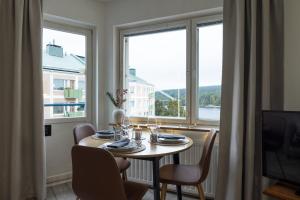 a dining room with a table and a large window at RIVER VIEW CITY NEST - Nordic Apartment With Views in Rovaniemi