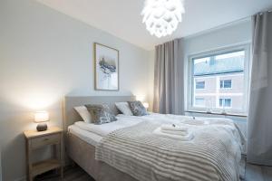 a bedroom with a large bed with a window at RIVER VIEW CITY NEST - Nordic Apartment With Views in Rovaniemi