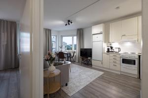 a kitchen with white cabinets and a table and a dining room at RIVER VIEW CITY NEST - Nordic Apartment With Views in Rovaniemi +8 photos