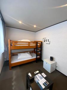 a room with two bunk beds and a table at Hostel SAMURISE 81INN in Fujikawaguchiko