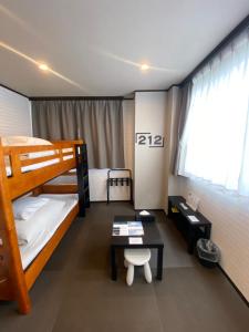 a bedroom with two bunk beds and a table at Hostel SAMURISE 81INN in Fujikawaguchiko +27 photos