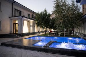a large blue swimming pool in front of a building at Turon Lux Hotel in Samarkand