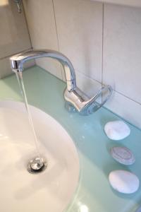 a sink with a faucet and three rocks in it at Evridiki's Villas in Agios Nikitas