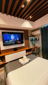 a bedroom with a bed with a flat screen tv on the wall at Modern Elegance Escape in Azure North Bali Tower near Malls, Airport and NLEX in San Fernando +12 photos