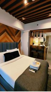 a bedroom with a large white bed and a kitchen at Modern Elegance Escape in Azure North Bali Tower near Malls, Airport and NLEX in San Fernando