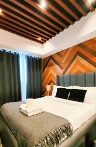 a bedroom with a large bed with a wooden wall at Modern Elegance Escape in Azure North Bali Tower near Malls, Airport and NLEX in San Fernando