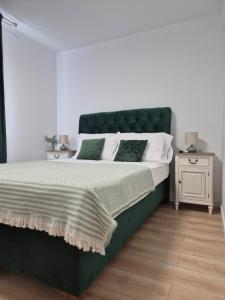 a bedroom with a large bed with a green headboard at D&D Central Apartment in Tulcea
