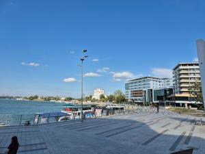 a boardwalk next to a body of water with buildings at D&D Central Apartment in Tulcea