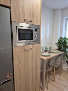 a microwave in a cabinet next to a table at D&D Central Apartment in Tulcea