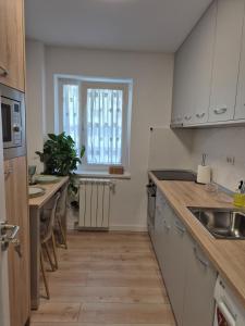 a kitchen with white cabinets and a table and a window at D&D Central Apartment in Tulcea +15 photos