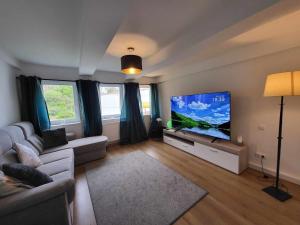 a living room with a couch and a flat screen tv at MaiFerien Harz - Haus Silberquelle - bis 14 Personen in Clausthal-Zellerfeld