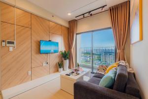 a living room with a couch and a large window at Masteri Thao Dien Riverside Apartment in Ho Chi Minh City