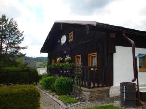 a black and white house with a fence at Apartmán Na Šumavě-Volary in Volary