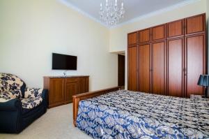 sypialnia z łóżkiem, telewizorem i krzesłem w obiekcie Apartamenty Kulisha 25 w Lwowie