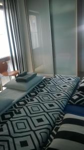 Una cama con una manta blanca y negra y una ventana en Jurata Apartment, en Jurata