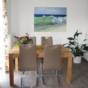 stół jadalny z krzesłami i obraz na ścianie w obiekcie Lieblingsplatz w mieście Kappeln