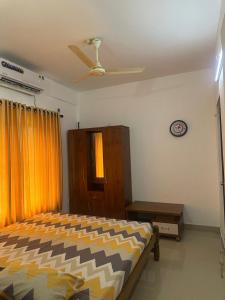 a bedroom with a bed and a ceiling fan at Guruvayur Soorya Madhavam Apartment in Guruvāyūr
