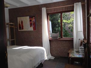 a bedroom with a bed and a window at Hofje7 in Groesbeek