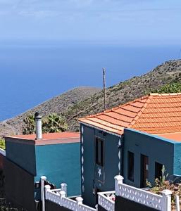 PuntallanaにあるCasa de campo con vistas al marの山の前にある柵のある青い家 +8枚の写真