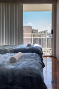 two beds in a room with a large window at Cosmopolitan Charm in Central Sydney in Sydney +13 photos