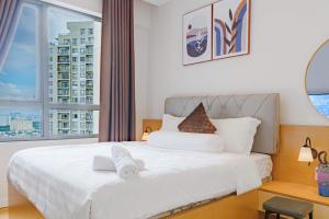 a bedroom with a white bed with a large window at The Vista Masteri Thao Dien N-Stay Apartment in Ho Chi Minh City +86 photos