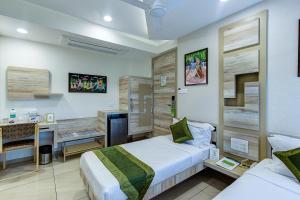 a hotel room with two beds and a desk at Treebo Trend Daksh Residency in Indore