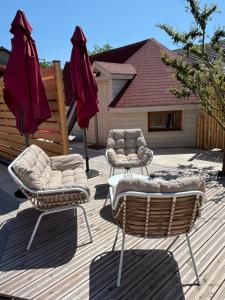 a couple of chairs and umbrellas on a deck at La Clé de L Insolite in Hudiviller