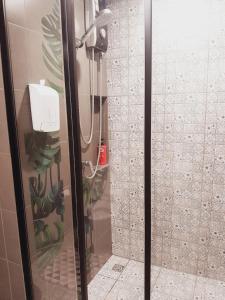 a shower with a glass door in a bathroom at La casita hua hin in Hua Hin